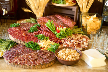 Artistic presentation of a gourmet charcuterie spread featuring a variety of meats and accompaniments at a rustic event