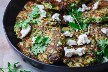 Green zucchini pancakes with feta and cilantro. Vegetarian breakfast recipe.
