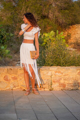 Elegant Woman in White Outfit Against Natural Background in Formentera, Balearic Islands, Spain.