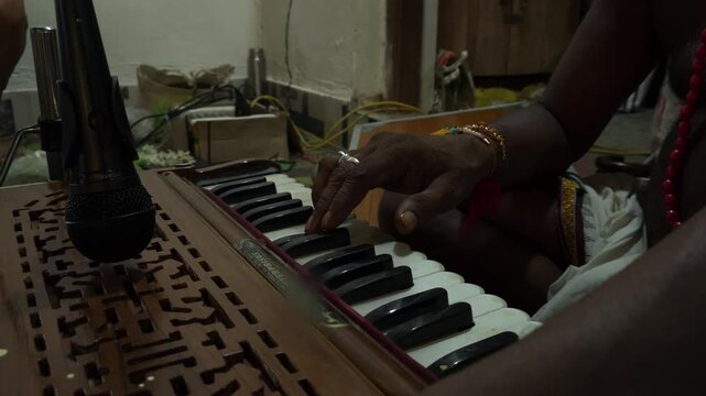 Indian man hands playing ethnic Indian classical harmonium keyboard on stage, close up view. Entertainment, music, culture, leisure time and art concept