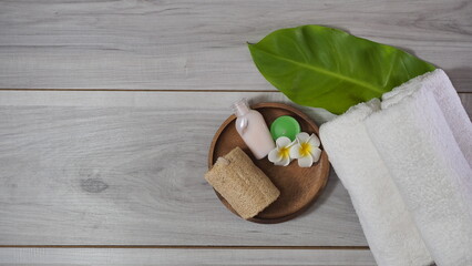 Spa-like setting with candles, flowers, and towel  Relaxing spa setup with towels and candle on marble tray in tranquil setting, copy space on the right