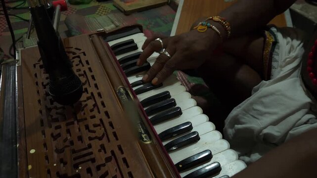 Indian man hands playing ethnic Indian classical harmonium keyboard on stage, close up view. Entertainment, music, culture, leisure time and art concept