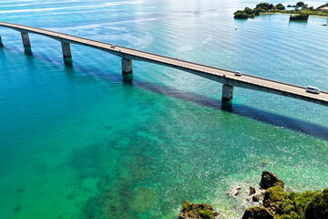 Aerial Drone View of Kouri Bridge (古宇利大橋) Stretching over Emerald Blue Sea, Okinawa, Japan