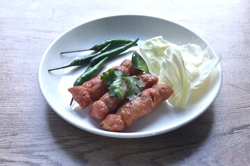 fried Thai north east sausage sfuffing fermenting chop pork and rice eat couple fresh cabbage with chili on plate