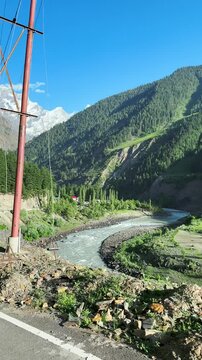4K Vertical shot of river Chenab flowing in between the Himalayan mountain peaks as seen near Killar town in Pangi Valley, Chamba district, Himachal Pradesh, India. Scenic view of flowing Chenab river