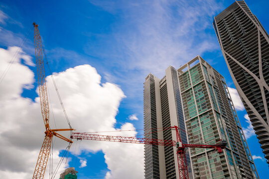 Downtown Miami view of cranes and skyscraper towers. Long exposure rolling clouds