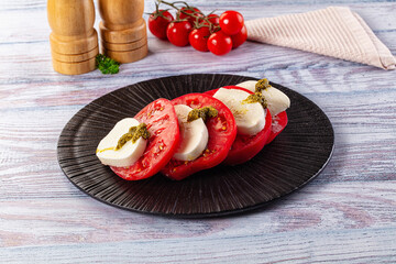 Italian Caprese salad with tomato, mozarella and pesto