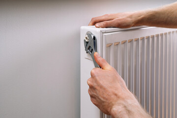 Man servicing a radiator to ensure home heating system works efficiently