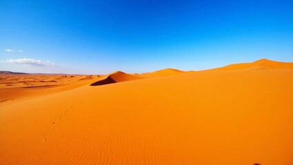 Fototapeta premium Vibrant Orange Sahara Desert Dunes Under Clear Blue Sky Footprints in Sand