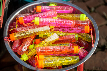 Colorful bubble wands in a metal bowl, ready for fun
