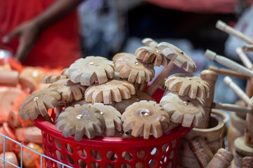 Handmade wooden star shapes in a red basket at a market
