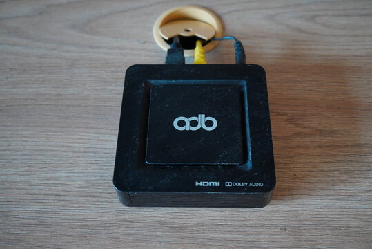 ADB IPTV Set-top Box with Cables on a Wooden Table