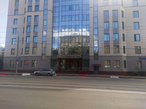 Russia, Moscow. August 17, 2025 izmailovsky district court with reflective glass facade and street with tram tracks and a parked car