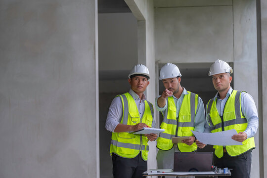 Group of Asian construction engineers discussing building plans at construction site, focusing on teamwork, site inspection, collaboration, civil engineering, and project management. - Powered by Adobe