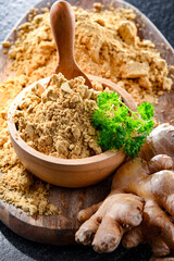 A bowl with ground ginger and its fresh rhizome