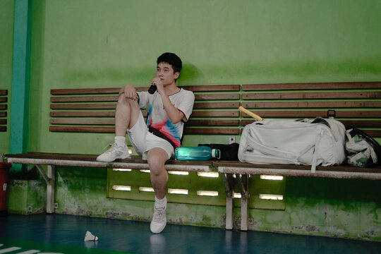 young man sitting on a bench in a sports center