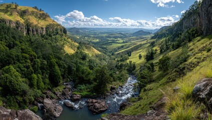 Panoramic view of a valley with a waterfall cascading down a rocky cliff