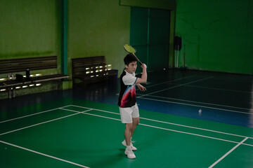 young man taking back shuttlecock in badminton court 