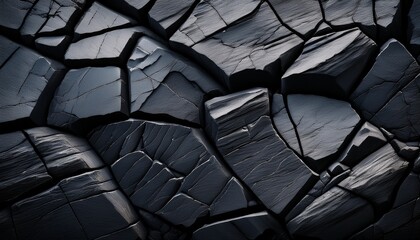 Fototapeta premium cracked black rock displaying deep stone fractures and rugged geological texture in a natural environment