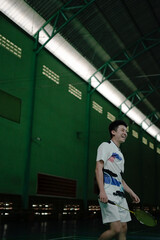 Active Young Man Playing Badminton in an Indoor Court Setting