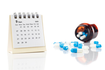 Medication schedule and treatment reminder concept. 2025 September calendar with pills and drug bottle for daily healthcare isolated on white background.