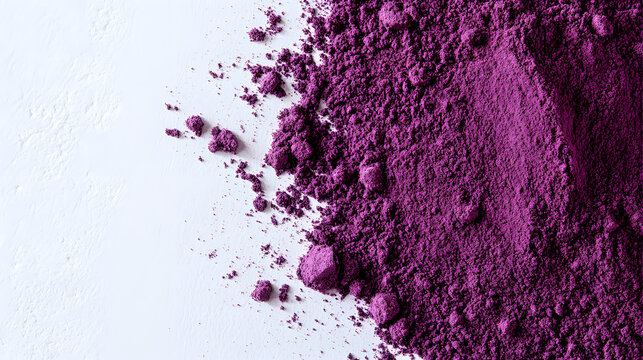 Vibrant purple sumac powder spread out on a white suface, showcasing its fine exture and color, perfect or a food styling shot.