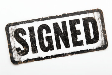 A close up of a rectangular stamp with the word signed in bold black letters on a white background