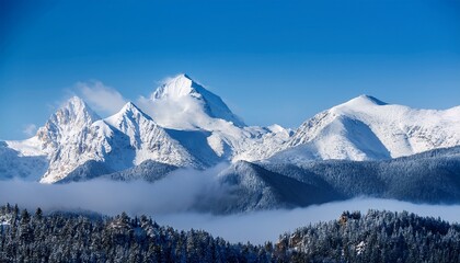 majestic snow capped mountain peaks rise against a blue sky shrouded in mist embodying the beauty of nature s winter wonderland
