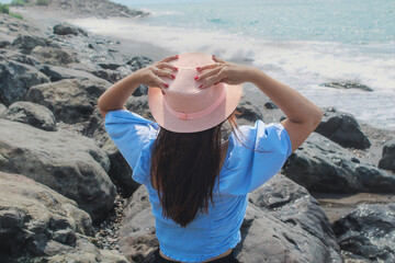 brunette girl in a hat looks at the seascape, seascape, girl in a pink hat on the beach at sea
