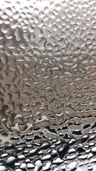 Photo of close up of water droplets clinging to a glass surface creating an abstract pattern