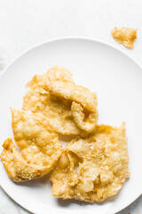 Overhead view of dublan northern nigerian snack, top view of dublan on a plate, flaky fried dough coated in syrup and sesame