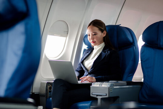 Successful professional business woman focused working laptop computer during airplane flight travel productivity remote work connectivity online