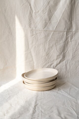 A set of handmade ceramic deep plates with a bowl like edge made from buff stoneware in a matt transparent glaze