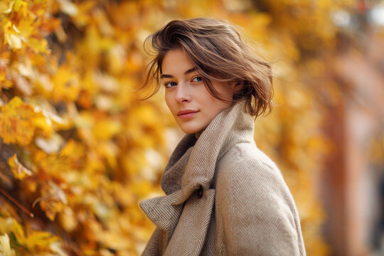 Woman standing outdoors in autumn leaves.