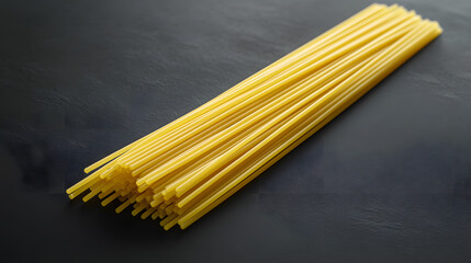 Spaghetti noodles loosely arranged on a dark backdro, emphasizing their smoothtexture and simple eleganc in a rustic setting.