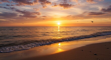 Obraz premium Beautiful sunset over the ocean, casting a warm golden glow on the water and beach