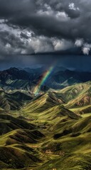 A vibrant rainbow arches over rolling green hills and dark, brooding storm clouds