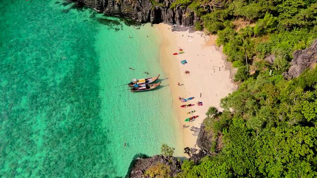 Aerial drone distancing view landscape bay turquoise lagoon Nui beach with long tail boat koh Phi Phi Don island Krabi Thailand