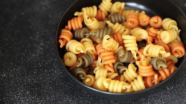 Pasta trottole tricolor pasta spiral dish twisted Italian food tasty snack fresh delicious gourmet food background on the table rustic top view copy space  vegan and vegan food