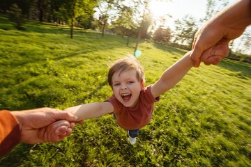 First-person view, father holding his son's hands, spinning him around in a circle at the park,...