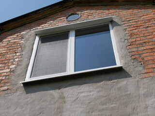  Attic Window on a Red Brick and Stucco Building