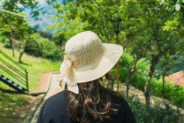 Back view of a young woman walking into the garden