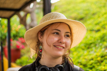 Smiling young Latina tourist wearing straw hat in Colombian countryside