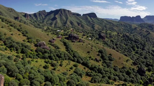 panoramic and scenic view of mountain range, large boulders, and distant villages at the Anja Community Reserve in Madagascar