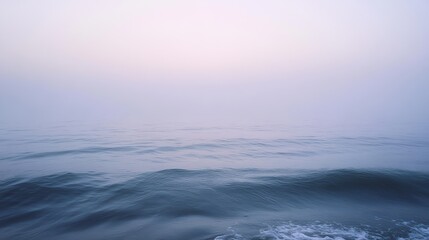 Fototapeta premium A serene seascape with soft waves and a misty, pastel sky, evoking calm and tranquility in a quiet marine environment.