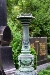 Obraz premium schöne alte Feuerschale als Säule mit Dekor auf einem Friedhof in Würzburg