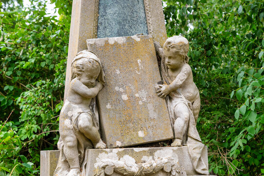 Zwei kleine Knaben halten eine Tafel auf einem Friedhof in W&uuml;rzburg