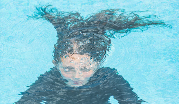 woman silhouette underwater in swimming pool