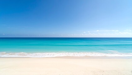 Fototapeta premium A tranquil beach scene showcases a serene turquoise ocean meeting a pristine white sand shore under a vast, clear blue sky.