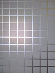 Frosted window film with a grid pattern creates a semi-private, decorative effect. Ideal for modern interiors, offering diffused light and elegant obscurity.